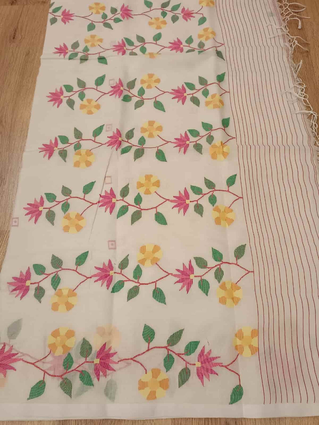 Pure Cotton handwoven jamdani saree in White & Multi Colour with a beautiful delicate & intricate floral weave on border & Aanchal. Geometric motifs woven all over the body. Blouse piece included.