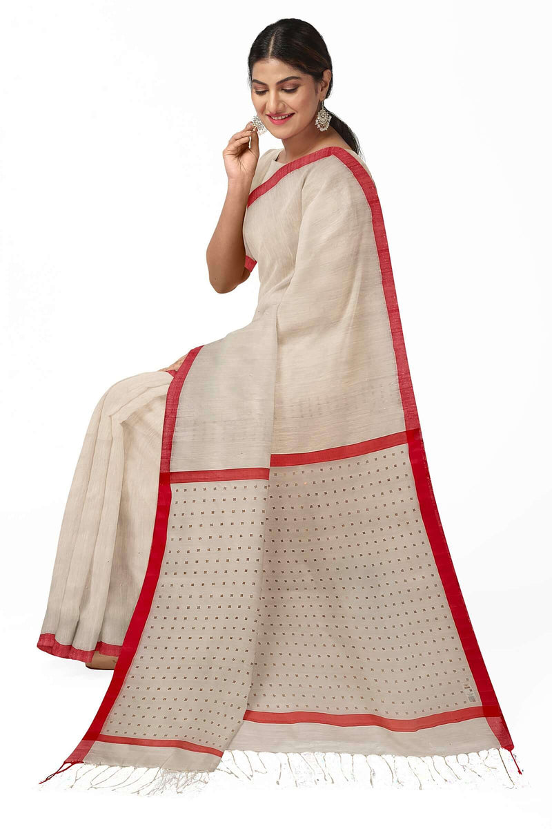 Introducing this elegant off-white and red handloom saree crafted from fine Matka silk and featuring a red satin plain border with subtly woven siqueen on the anchal and blouse. This saree is perfect for any formal occasion and is sure to make you stand out.